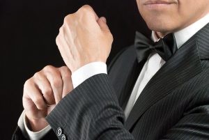 close-up of a man in a tux fixing his cufflink
